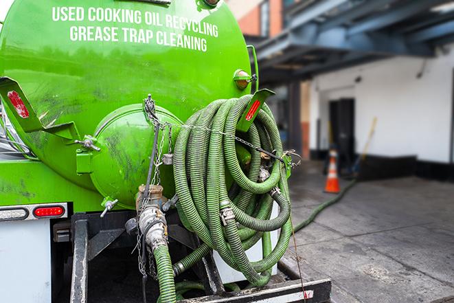 worker pumping grease trap at commercial kitchen in East Boston